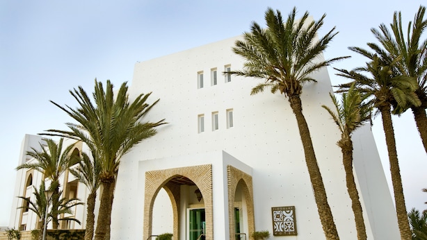 A modern building with a white facade, multiple windows, and a prominent entrance with an archway. - Timoulay Hotel & Spa Agadir (Agadir)