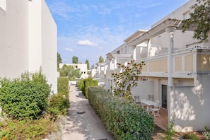 Zona residencial con edificios blancos, un camino y vegetación.