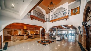 Un vestíbulo amplio con mostrador de recepción, zona de comedor y escalera que conduce a un nivel superior.
