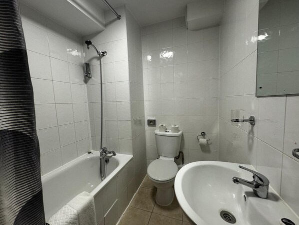 A bathroom with a bathtub, toilet, and sink.