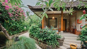 A traditional building with a tiled roof, a stone pathway leading to a wooden door, and lush greenery surrounding the entrance. - Kuta Seaview Beach Resort    (Kuta)
