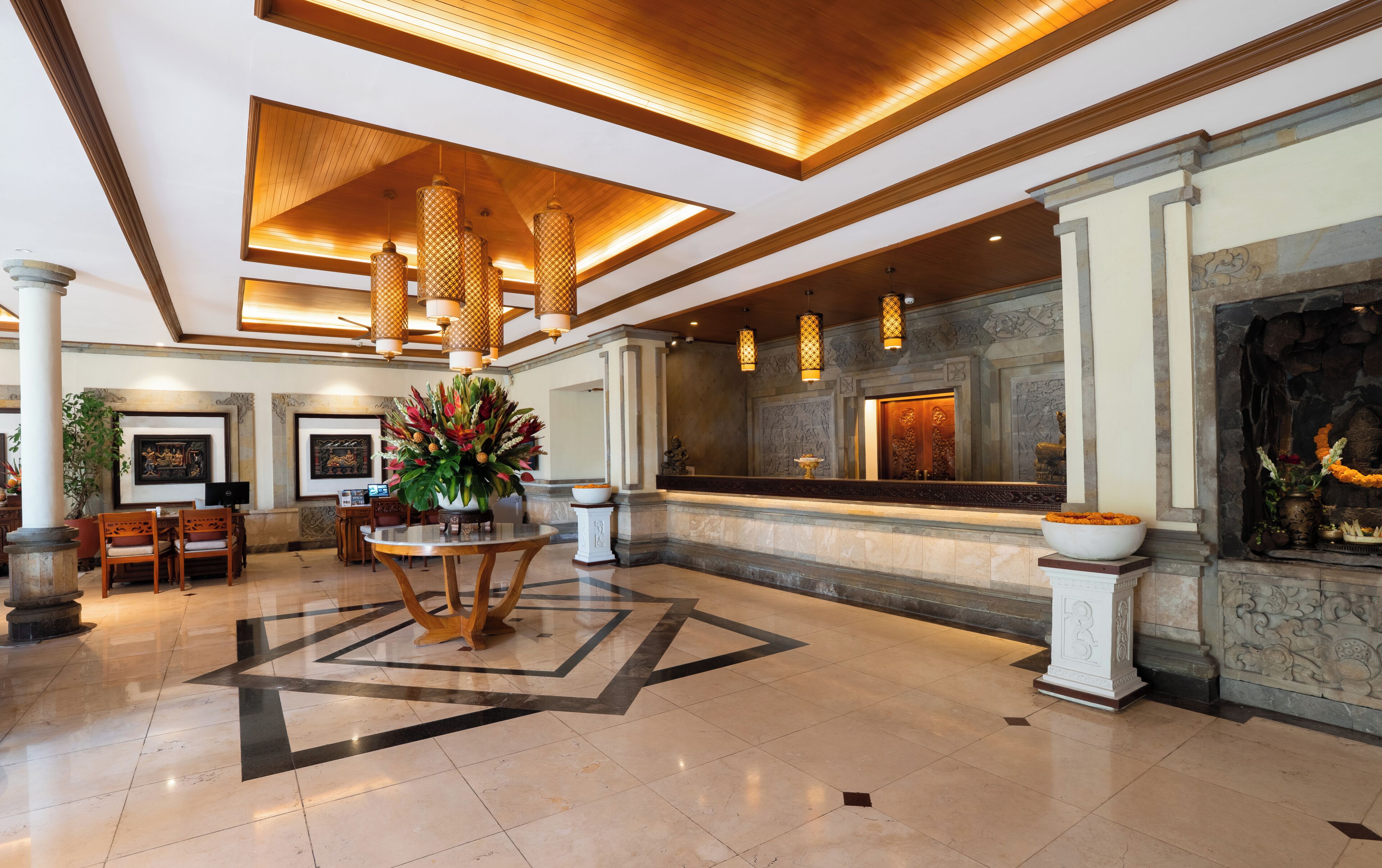 Eine Lobby mit einer Rezeption, einer großen Ziervase und einem steinernen Kamin.