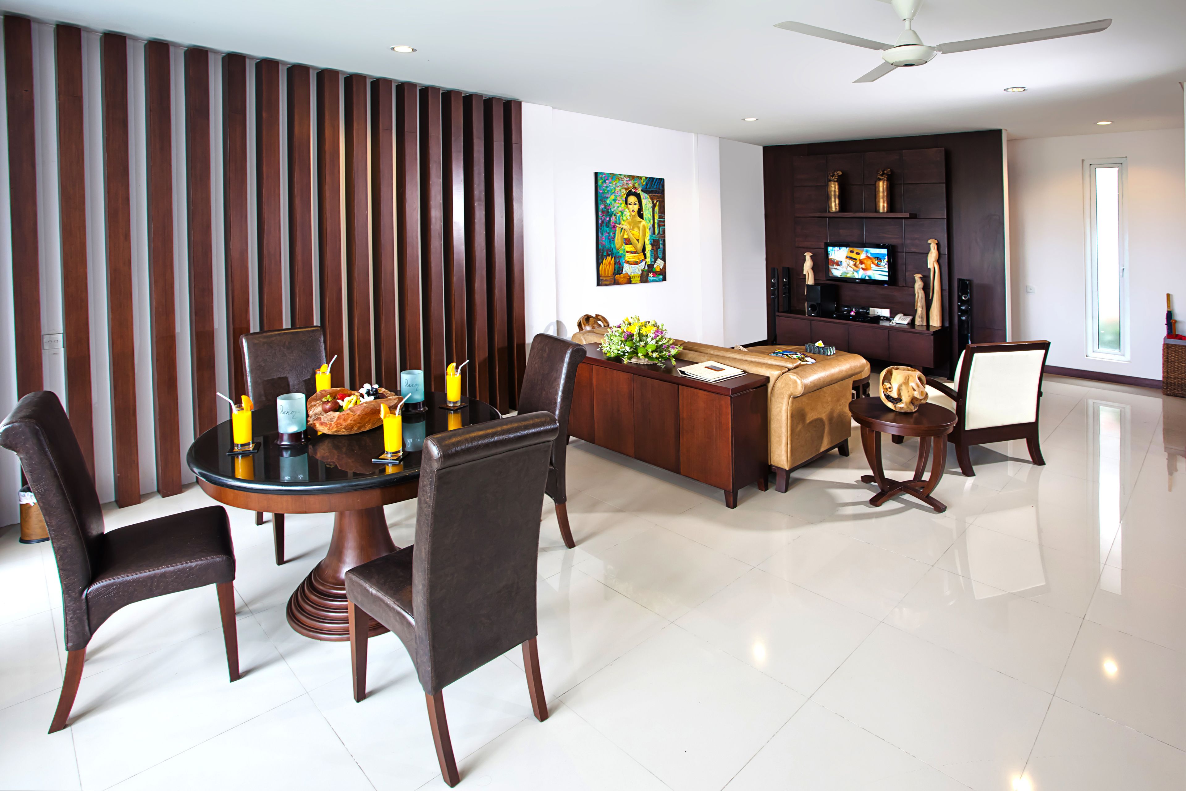 A modern dining area with a round table, dark chairs, and a decorative centerpiece.