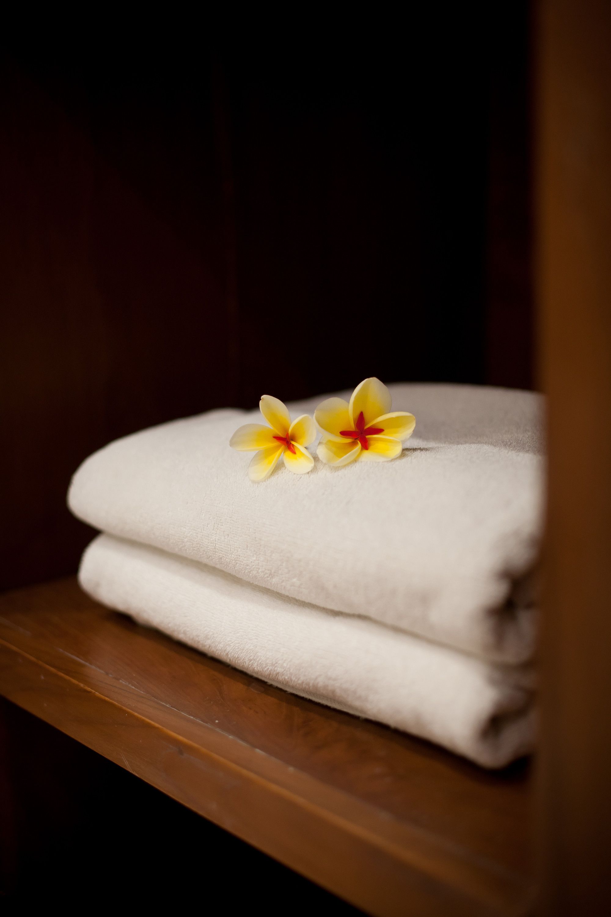 A stack of white towels on a wooden surface.