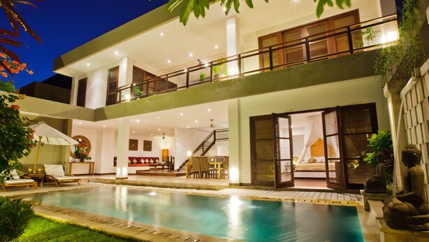 Une maison moderne à deux étages, dotée d’une piscine, d’un balcon et d’un escalier menant à l’étage supérieur.