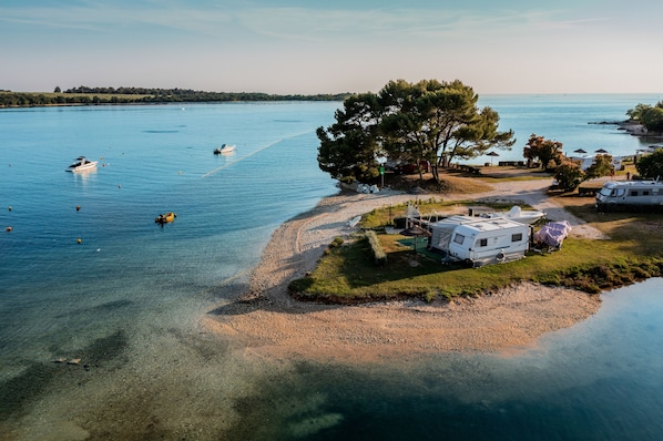 A lakeside RV park with clear water, boats, and trees. - Solaris Residence - Naturist (Tar-Vabriga)