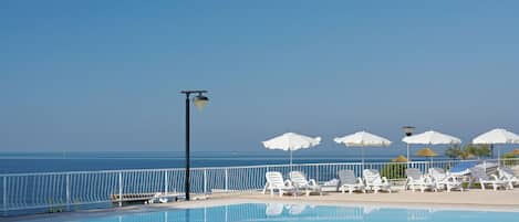 Piscine extérieure, parasols de plage, chaises longues