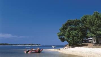 Sulla spiaggia, lettini da mare, ombrelloni, pallavolo