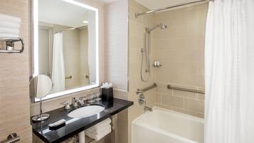 Un baño moderno con un espejo grande, un lavabo, una bañera y una ducha.