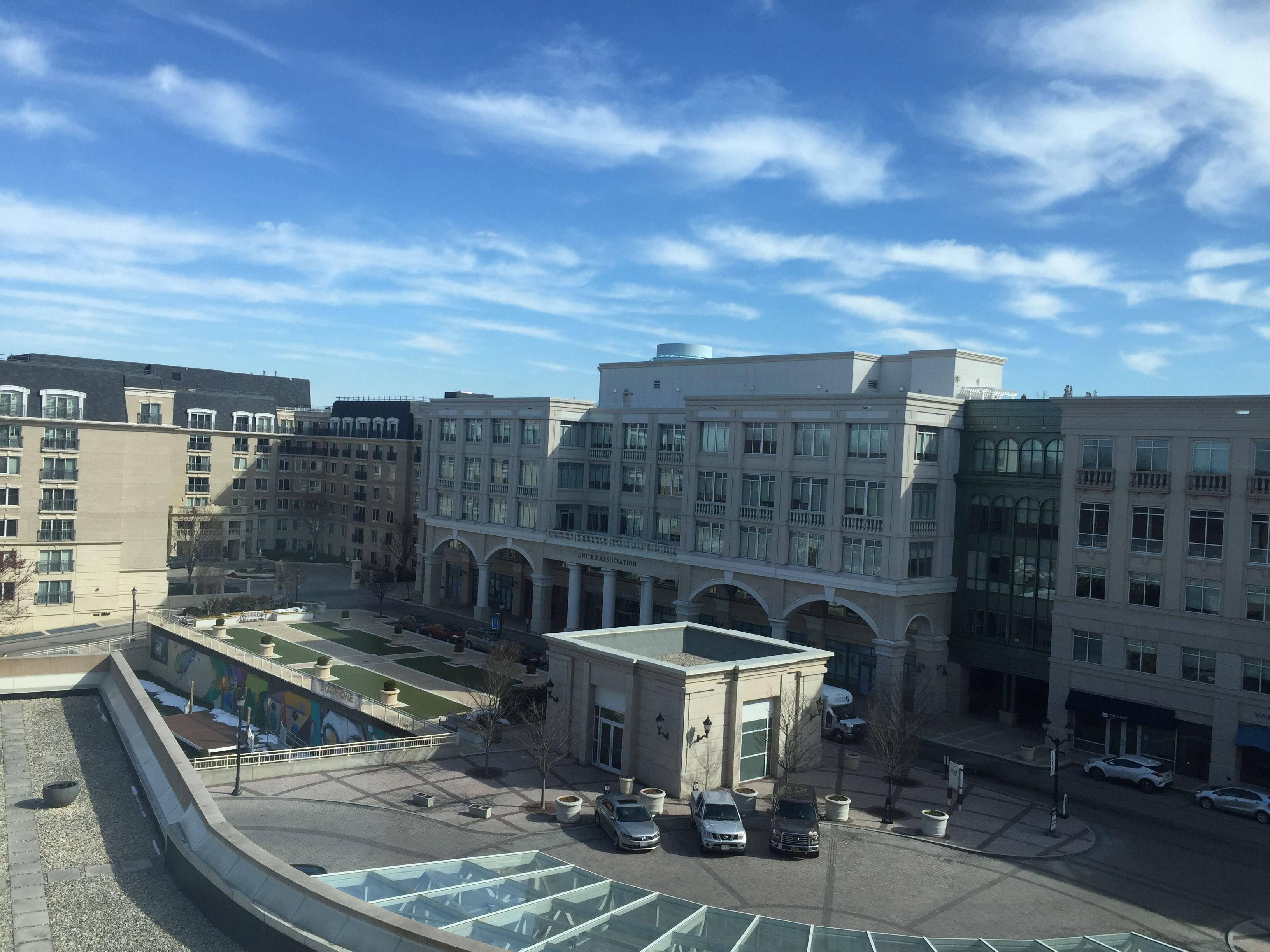 A multi-story building with a central courtyard, surrounded by other buildings.