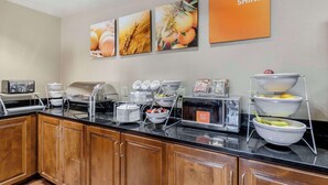 A breakfast buffet setup with various food items and a coffee station.