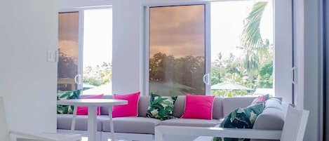 A modern living room with a sofa set, a coffee table, and a dining table.