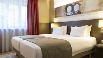 A hotel room with a large bed, two bedside lamps, a painting on the wall, and a window with curtains.