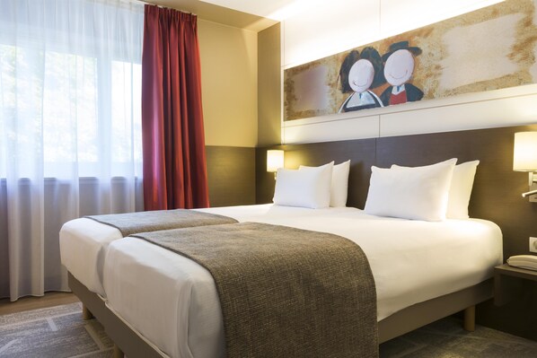 Habitación de hotel con una cama grande, dos lámparas de noche, un cuadro en la pared y una ventana con cortinas.