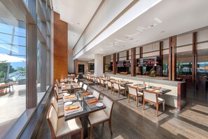 A modern restaurant with a long dining area, high ceilings, and large windows. - Shanghai Zhangjiang Parkyard Hotel (Shanghai)