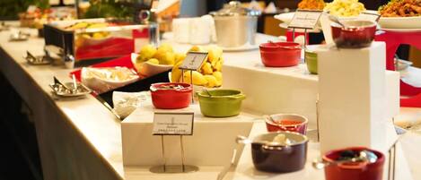 A buffet with various food items and condiments.