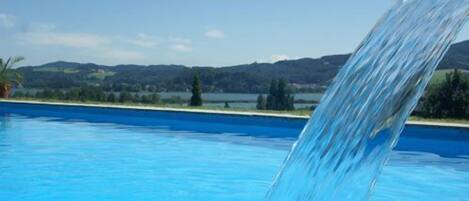 Una piscina al aire libre de temporada, sombrillas