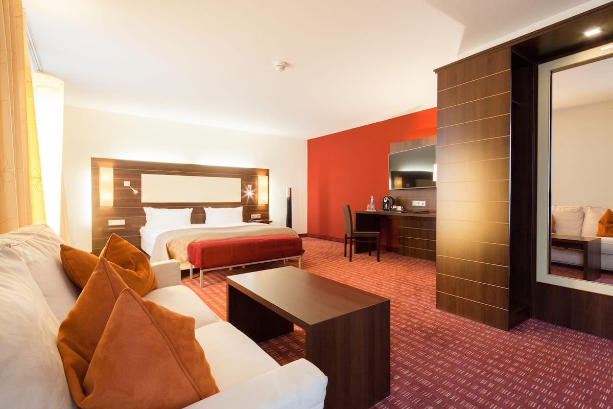 Een hotelkamer met een bed, bureau, bank en salontafel.