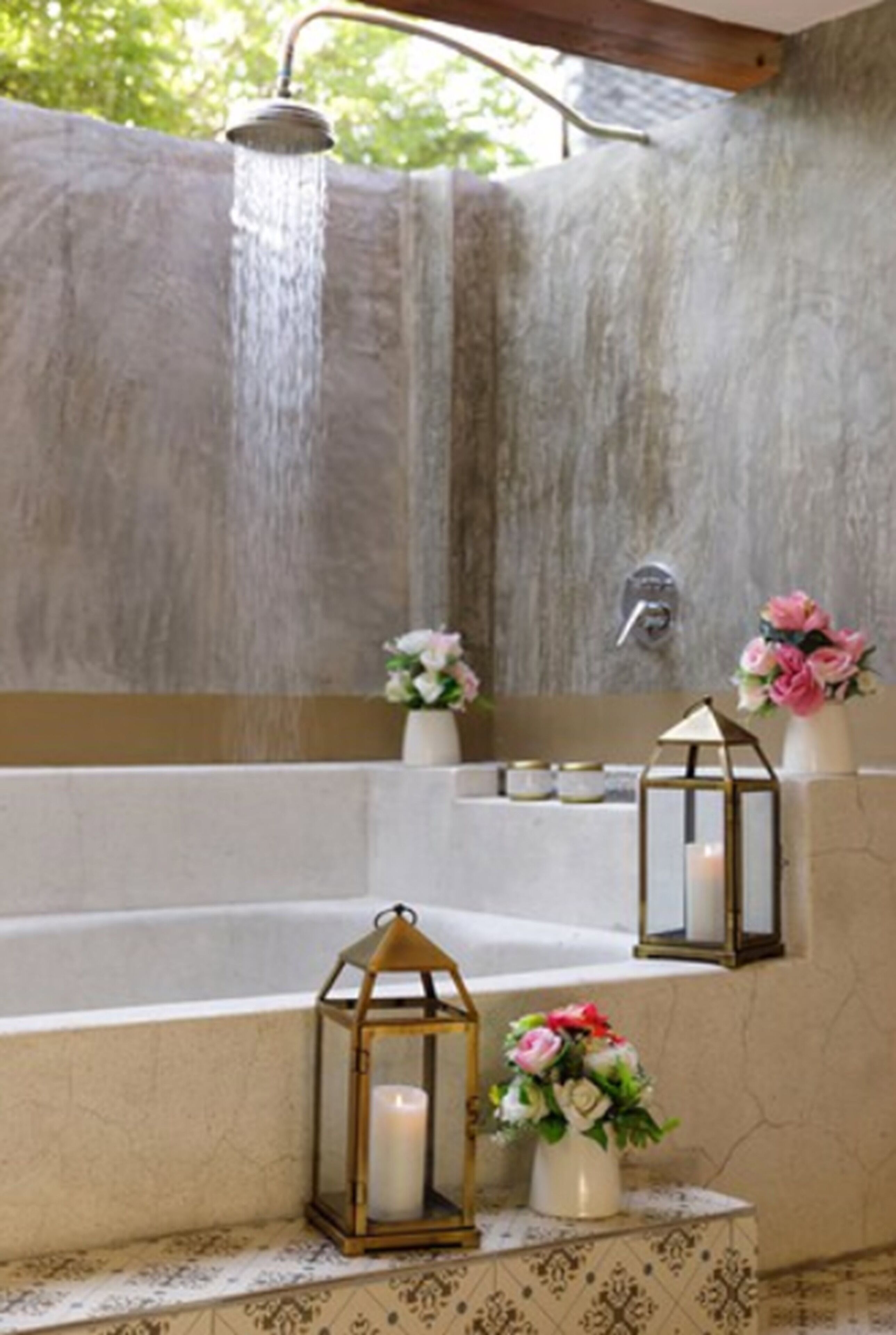 Ein Badezimmer mit einer Badewanne, einer Duschbrause und dekorativen Laternen.