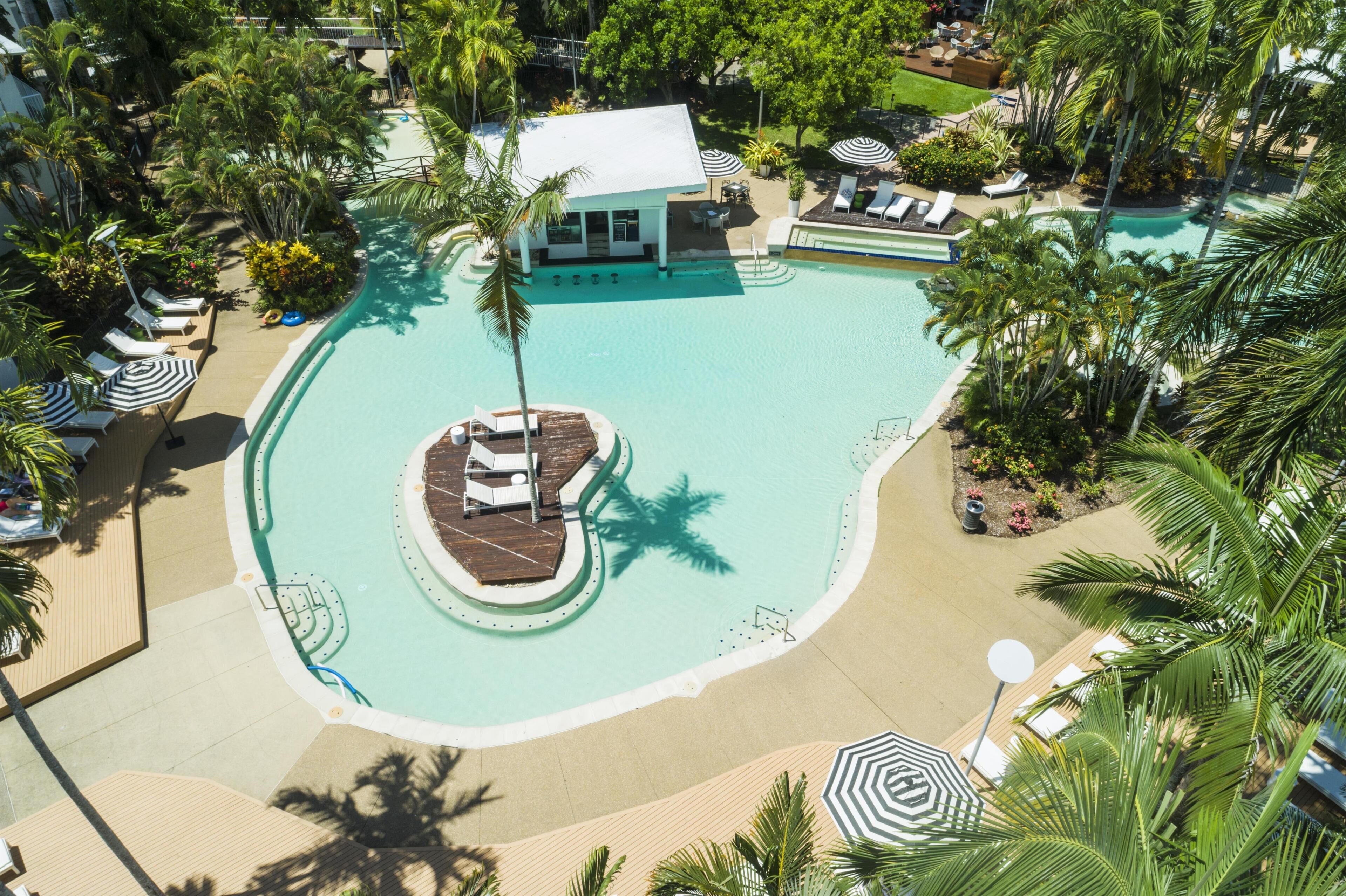 Un complexe hôtelier doté d’une piscine centrale, d’espaces de détente et d’un petit quai pour bateaux.