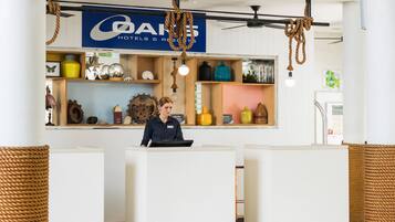 A reception area with a sign for 'DAN'S HOTELS & RESORTS', a reception desk, and various decorative items on shelves.