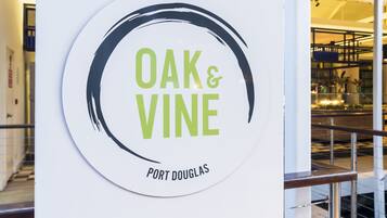 A circular sign with "OAK & VINE" and "PORT DOUGLAS" text.