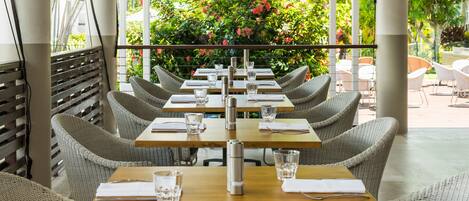 Un restaurante con terraza, mesas y sillas.