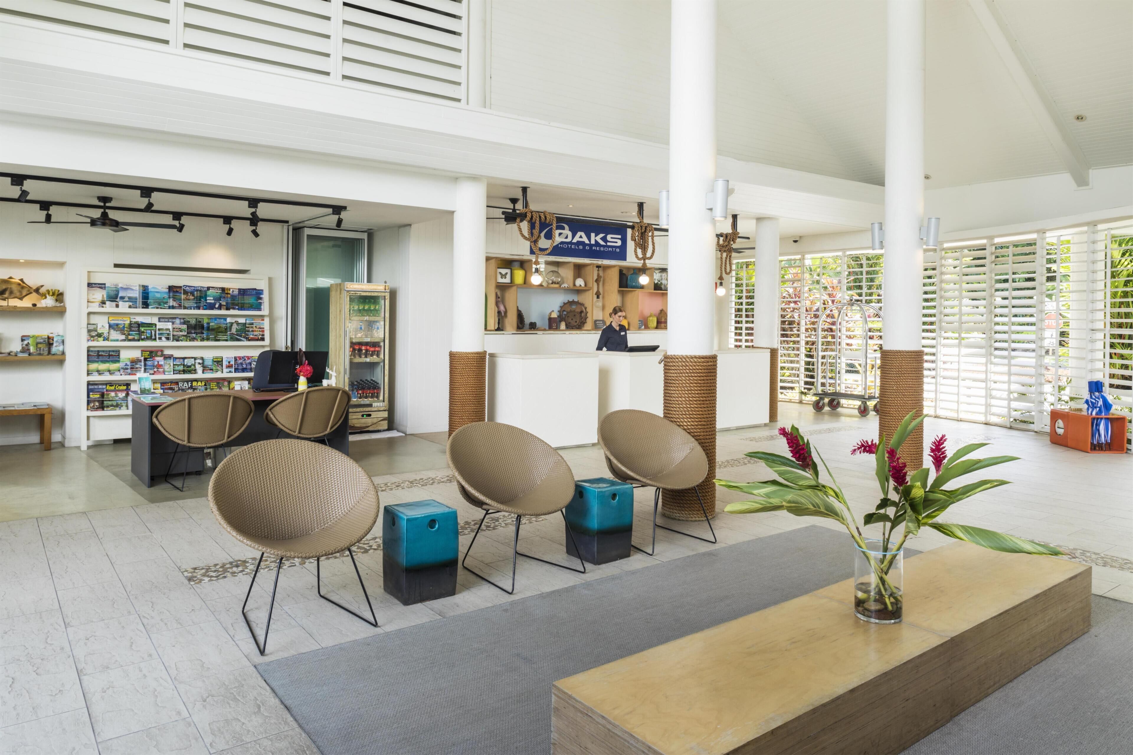 A spacious lobby with a reception desk, seating area, and a view of the outdoors.