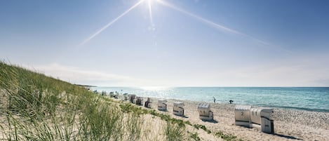 On the beach, white sand, sun loungers, beach towels