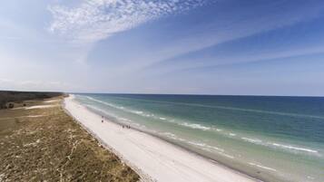 A beach with a wide sandy shore and a clear view of the ocean.