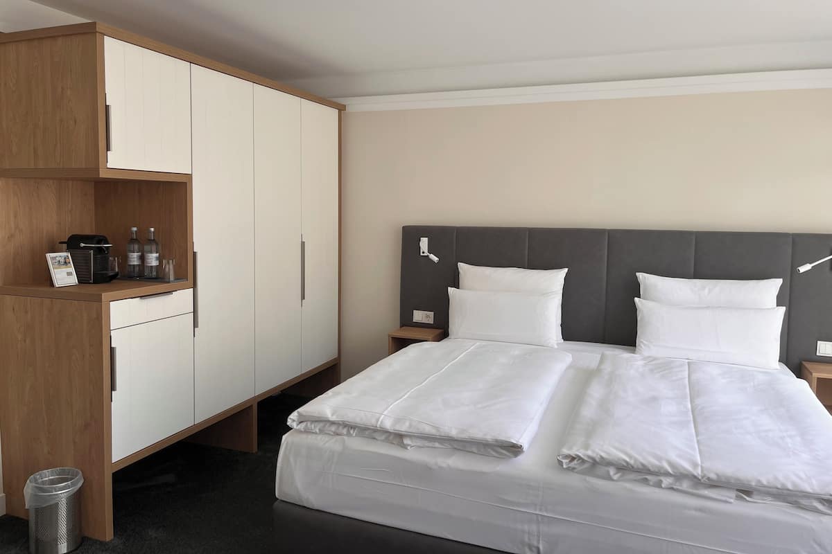 Ropa de cama hipoalergénica y caja de seguridad en la habitación