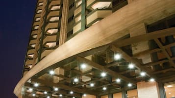 Ein hoch aufragendes Hotel mit modernem architektonischen Design, das einen geschwungenen Eingang und mehrere Stockwerke aufweist.