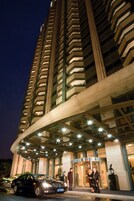 A high-rise hotel with a modern architectural design, featuring a curved entrance and multiple floors.