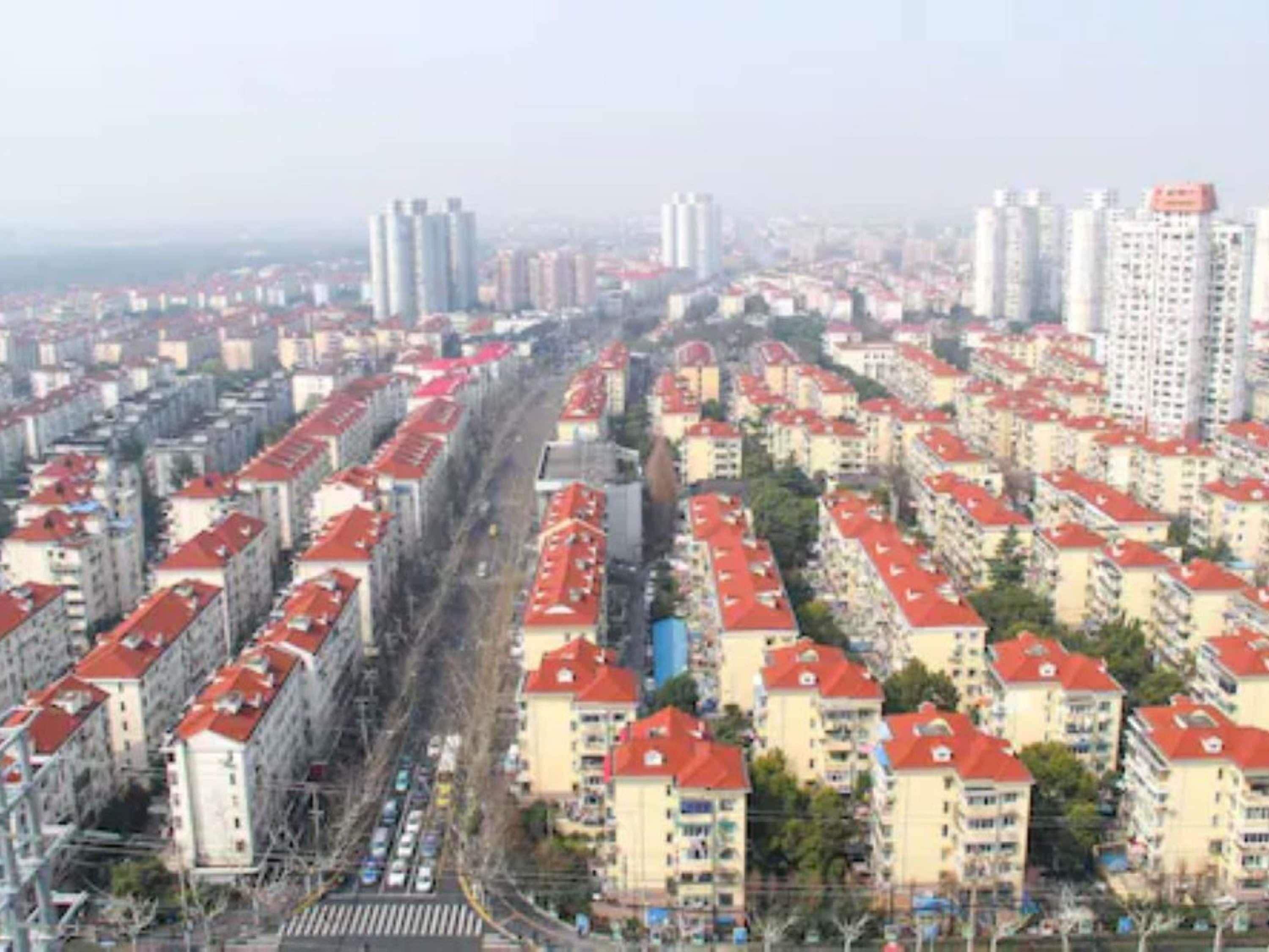 Un quartier résidentiel composé de nombreux immeubles à étages, chacun ayant un toit rouge et présentant un style architectural uniforme.