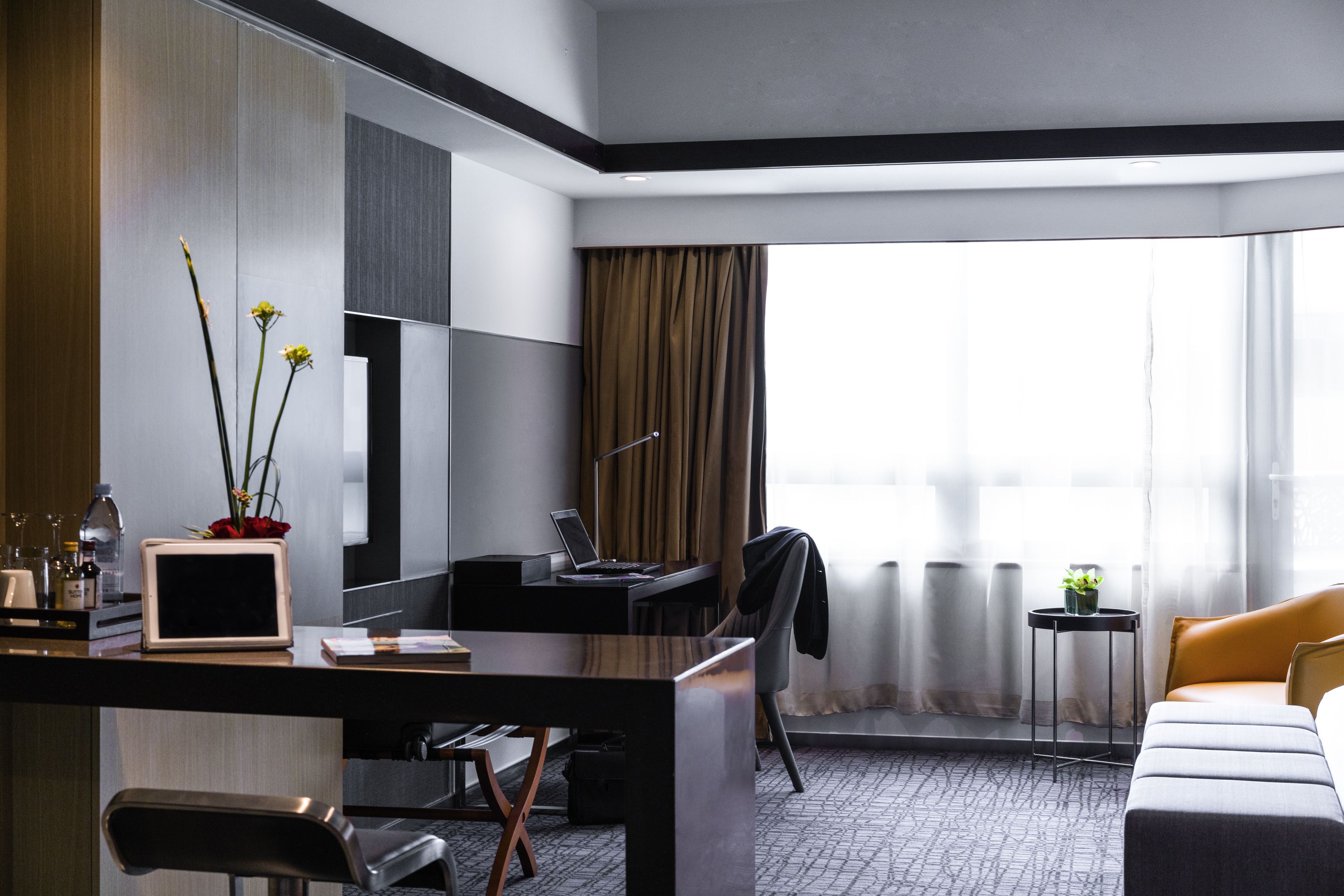 Une chambre d’hôtel moderne équipée d’un bureau, d’une chaise et d’un lit.