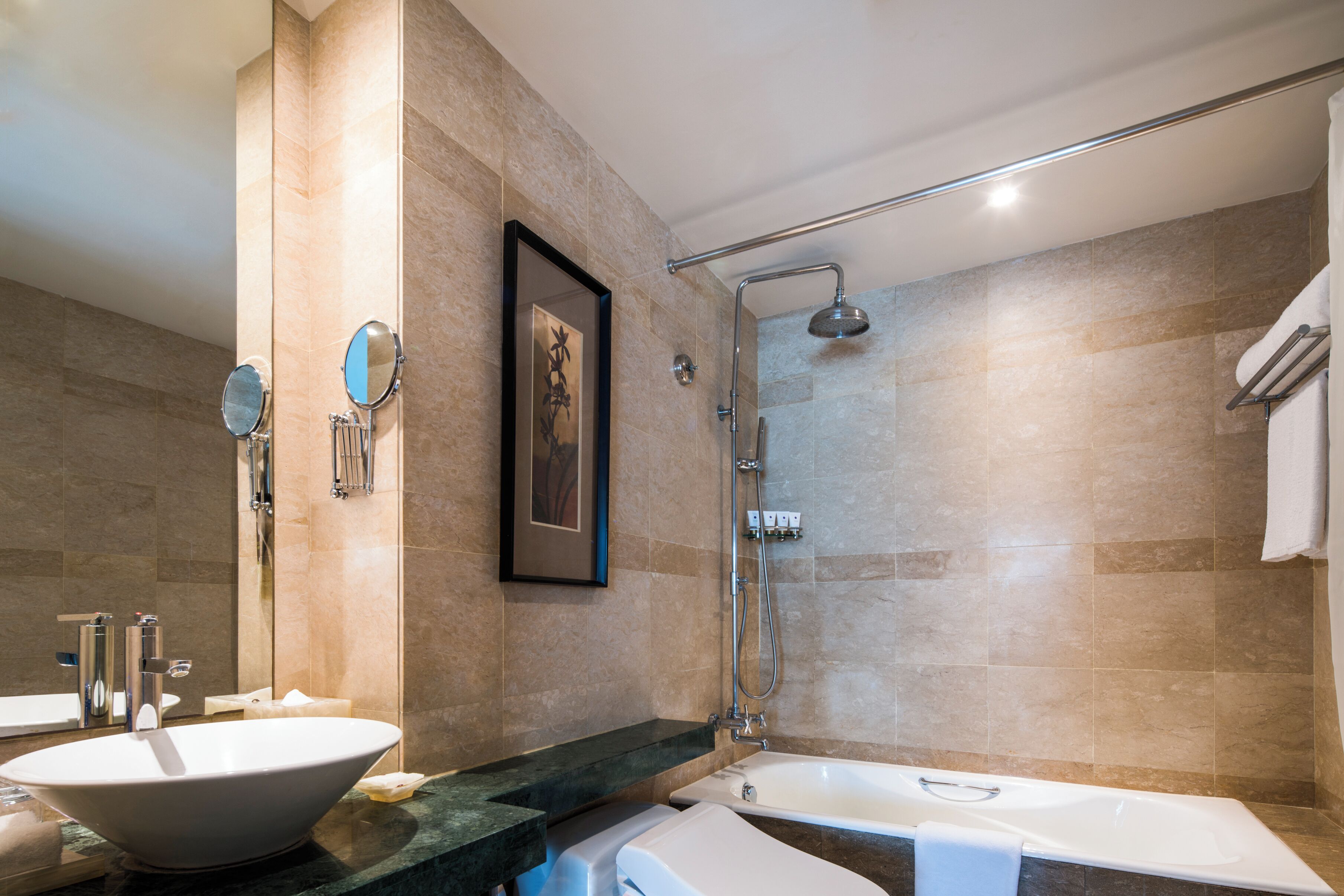 A modern bathroom with a freestanding bathtub, a large mirror, and a shower area.