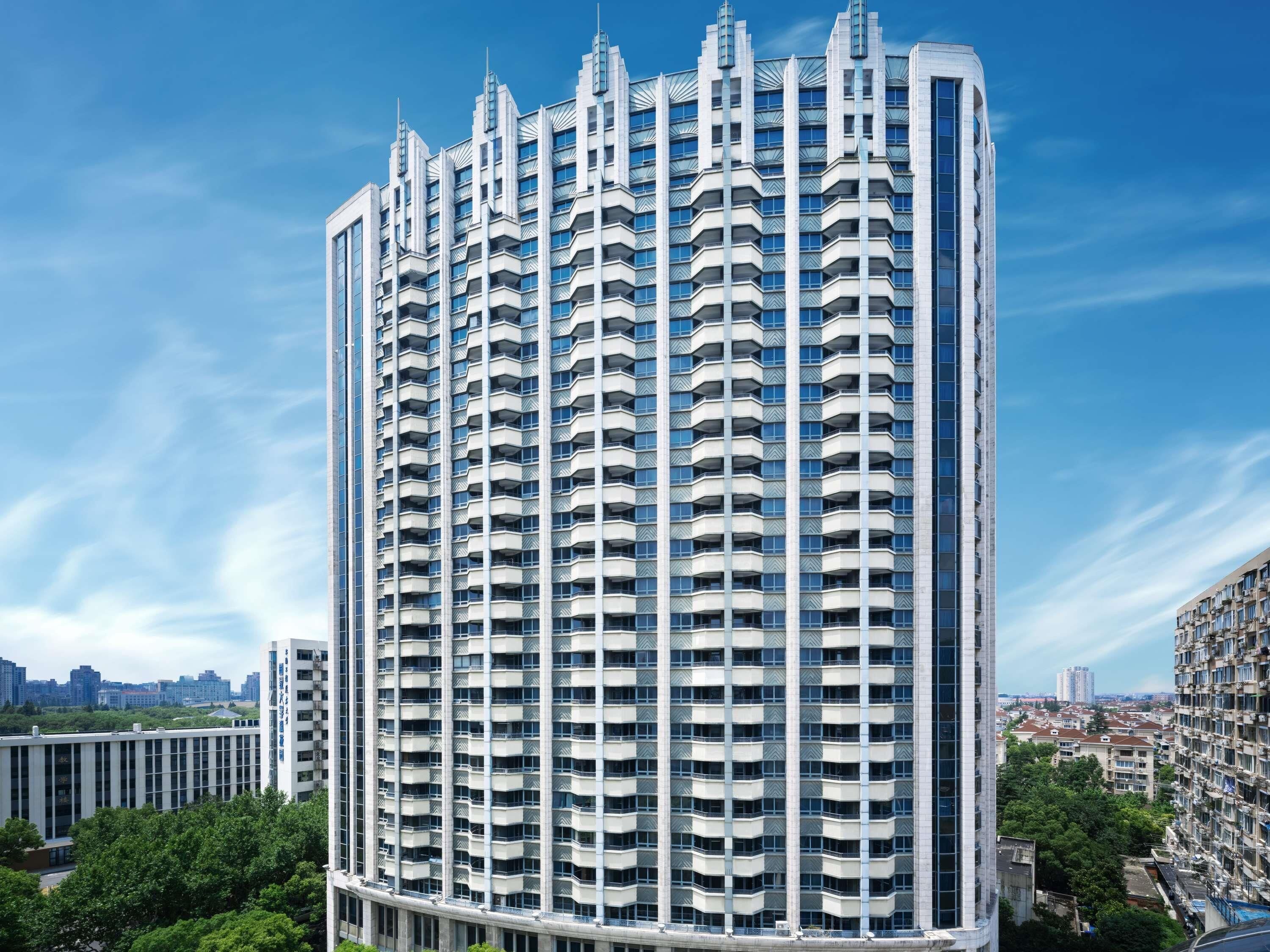 Un immeuble de grande hauteur doté d’une architecture moderne, avec de nombreux balcons et une vue dégagée sur le paysage urbain environnant.