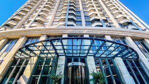 A tall building with a curved glass entrance and a sign reading "Grand Mercure."