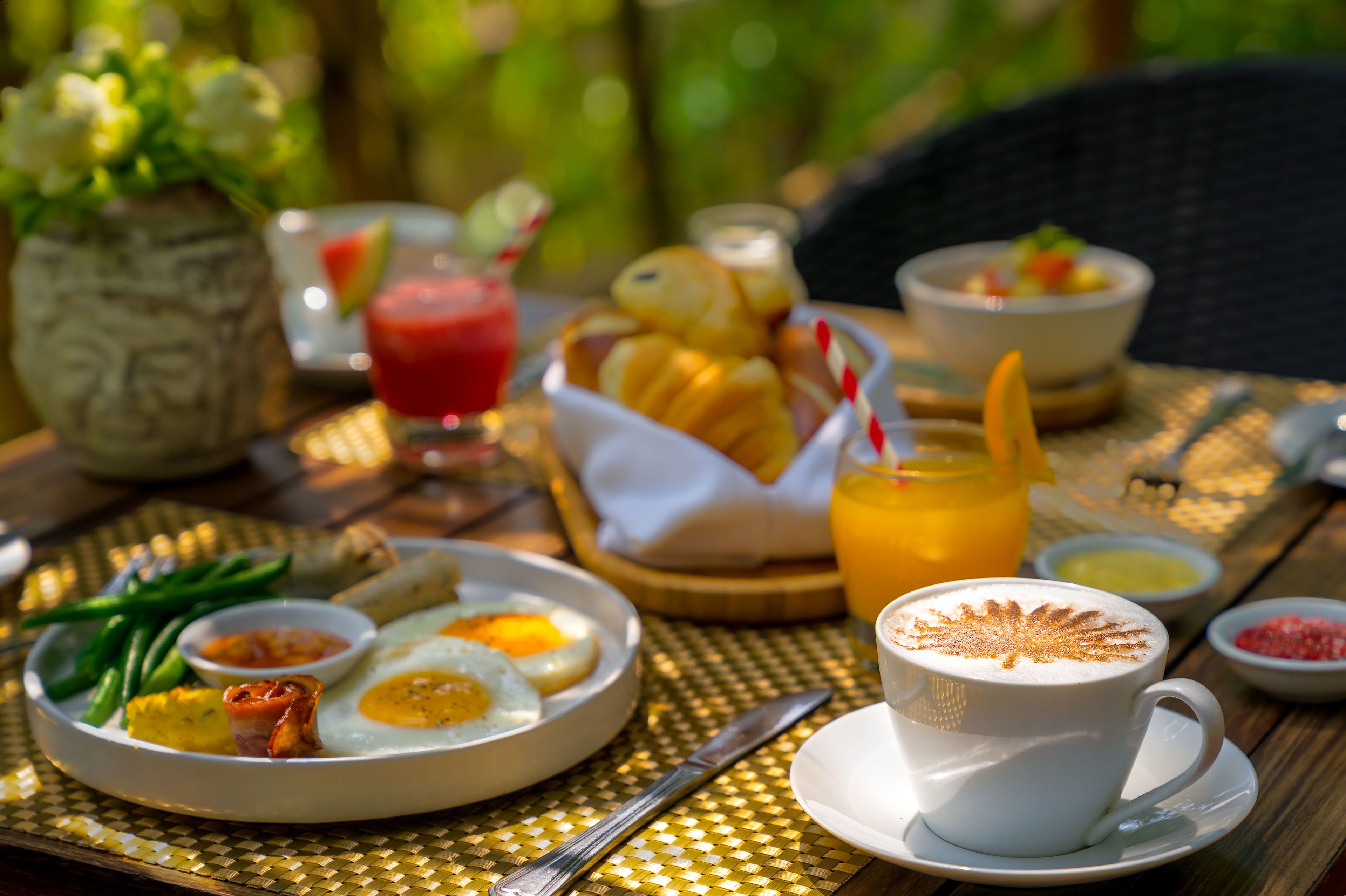 Un desayuno con huevos, judías verdes y una taza de café sobre una mesa.