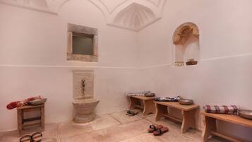 Traditional room with a stone sink, small window, and wooden bench.