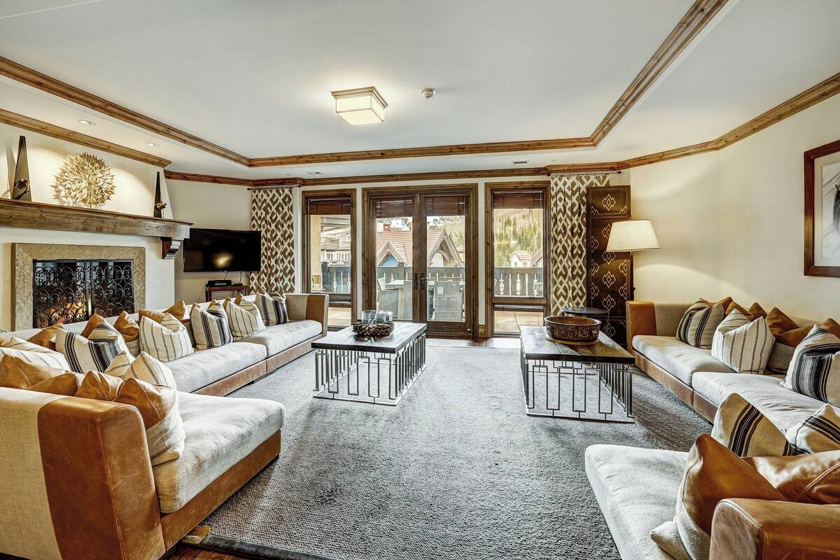 A spacious living room with two sofas, a coffee table, and a fireplace.