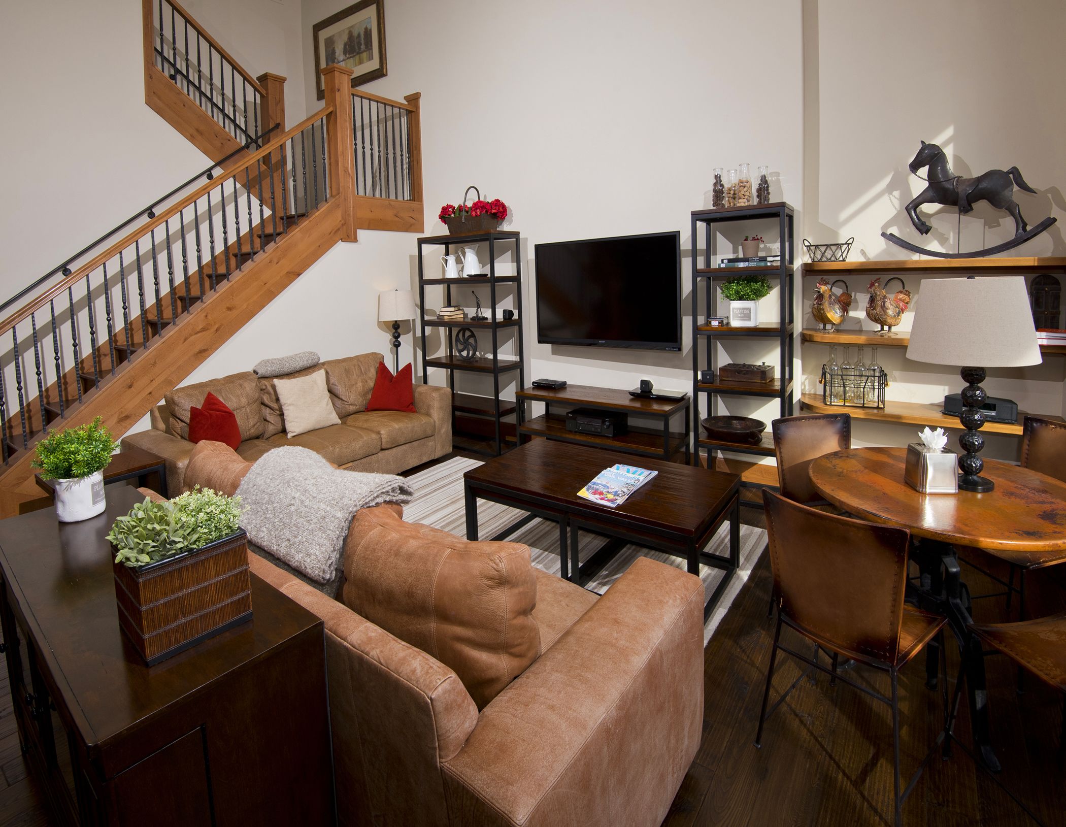 A living room with a sofa, coffee table, TV, and a staircase.