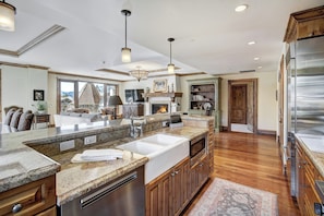 A spacious kitchen with granite countertops, stainless steel appliances, and wooden cabinetry.