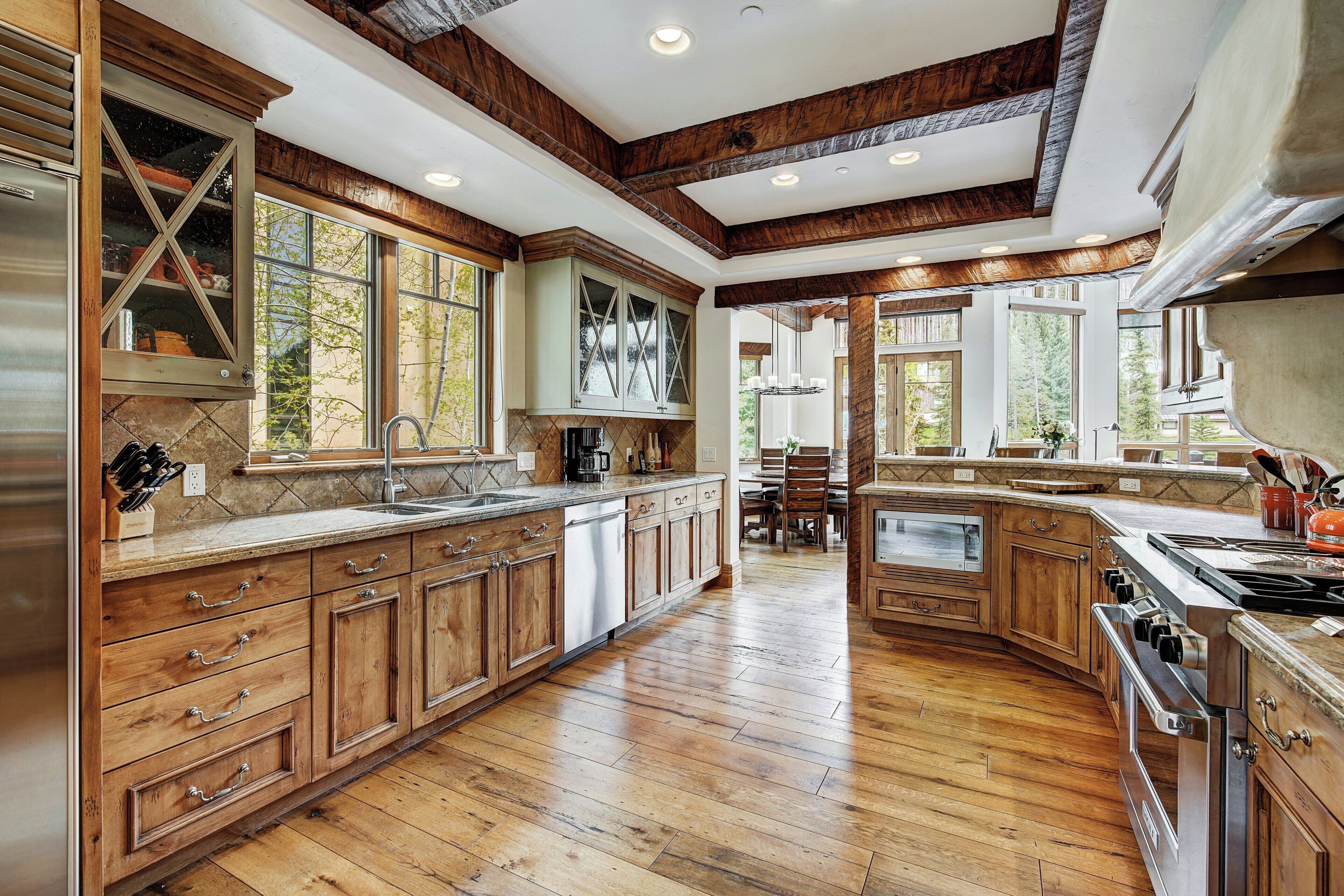 A spacious kitchen with wooden cabinets, a large island, and a built-in oven.