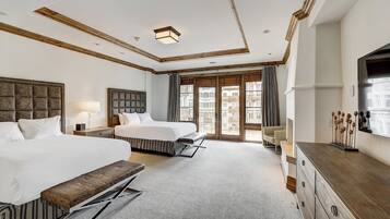 Une chambre d’hôtel avec deux lits, une grande fenêtre, une commode en bois et un téléviseur.