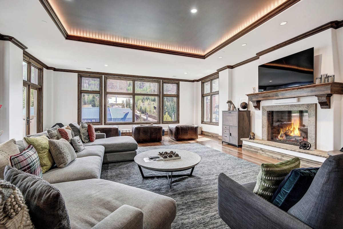 A spacious living room with a large sofa, a coffee table, and a fireplace.