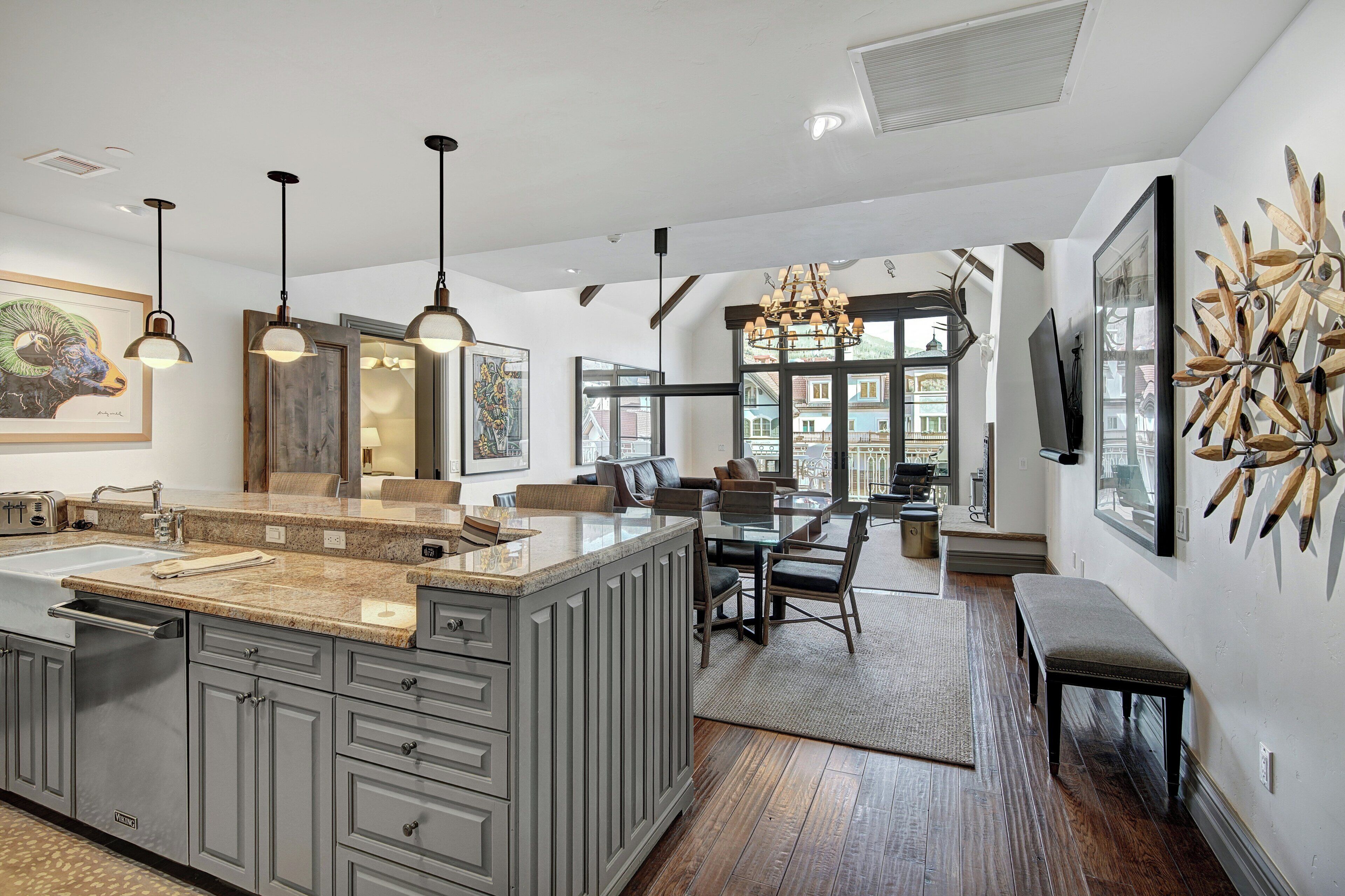 A spacious kitchen with a large island, pendant lighting, and a dining area with a bench.