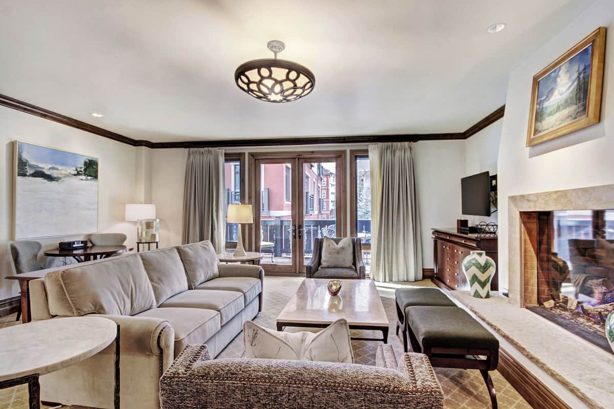 A spacious living room with a sofa set, a coffee table, and a fireplace.