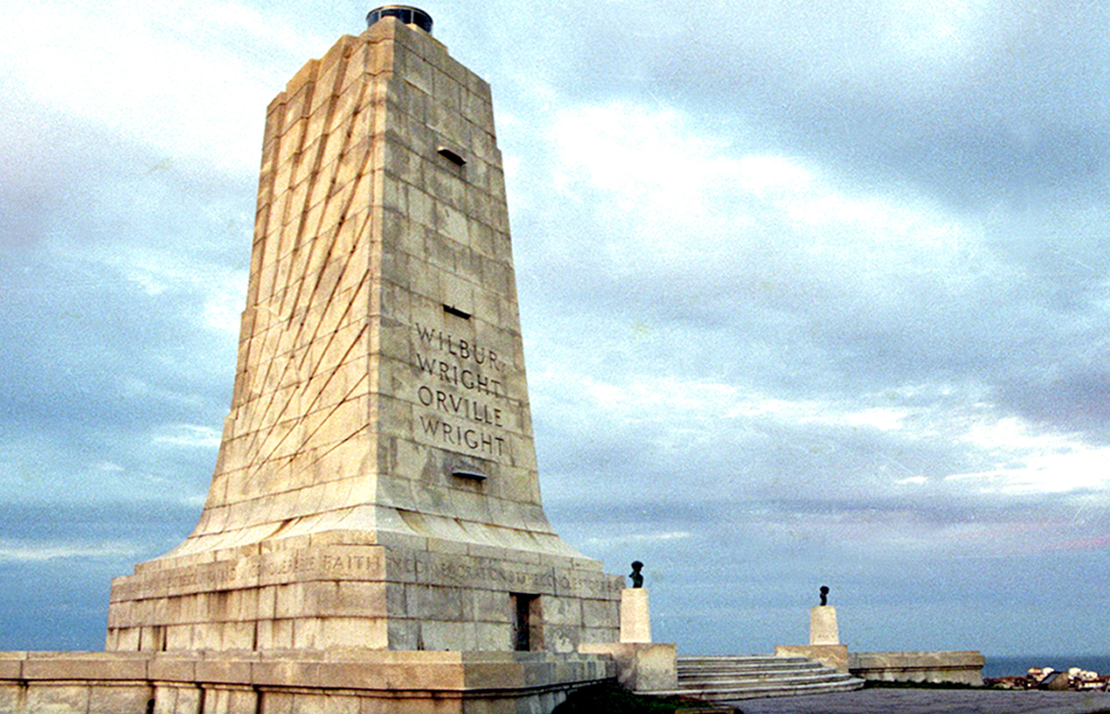 A tall monument with inscriptions, a base platform, and a smaller structure at the base.
