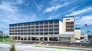 A multi-story hotel with a blue and white facade, a parking lot, and a clear sky. - Holiday Inn Express Nags Head Oceanfront by IHG (Nags Head)